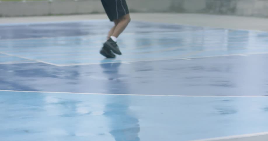 Man dribbles basket ball and does layup