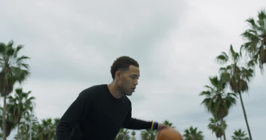 A young man dribbles a basketball