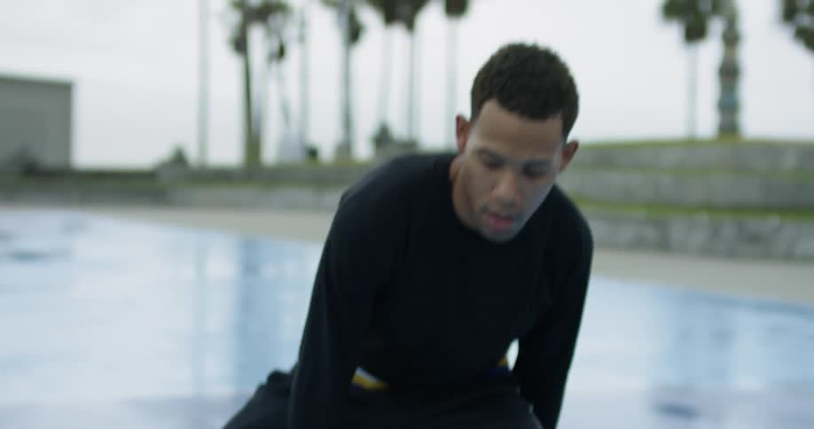 A man bouncing a basketball between his legs