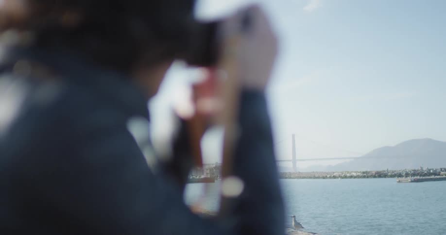 A woman taking a photo of a river