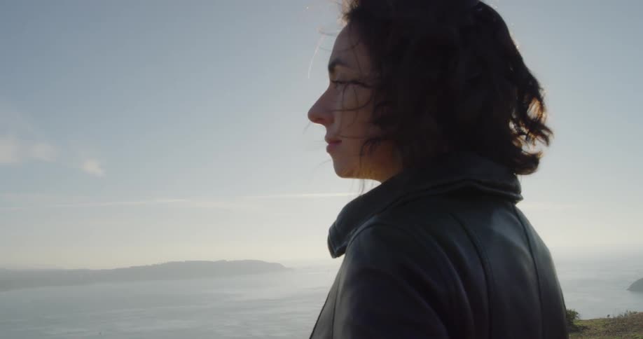 Woman looks out at the lake under the bright sun