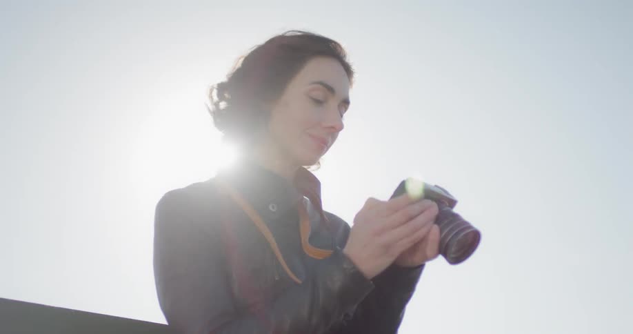 A woman is checking her camera