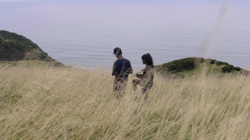 A man and woman walking in a grassy yellow field