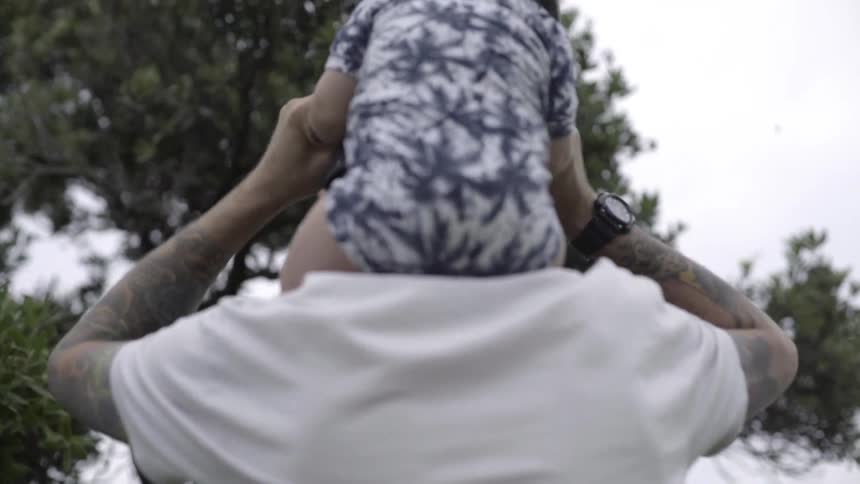 Man Carrying a Young Child on His Back, Expressing Care, Playfulness, and Togetherness.