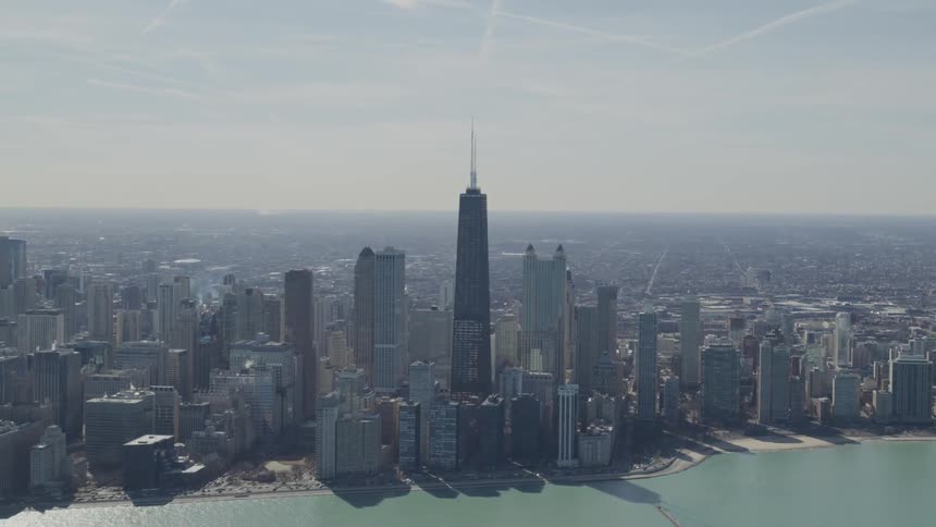 A tall tower stands in the middle of a metropolitan city