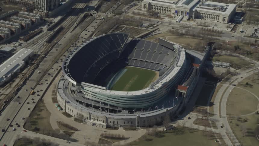 An empty sports stadium near a freeway during the day