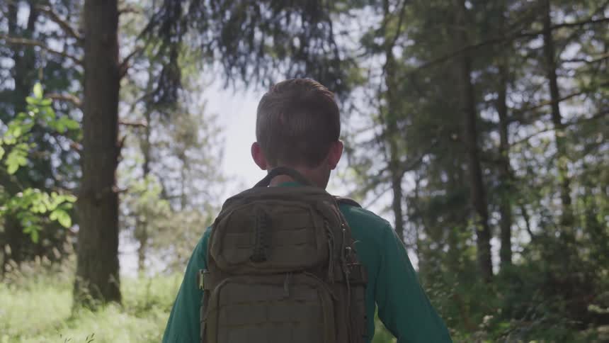 A child hikes through a forest