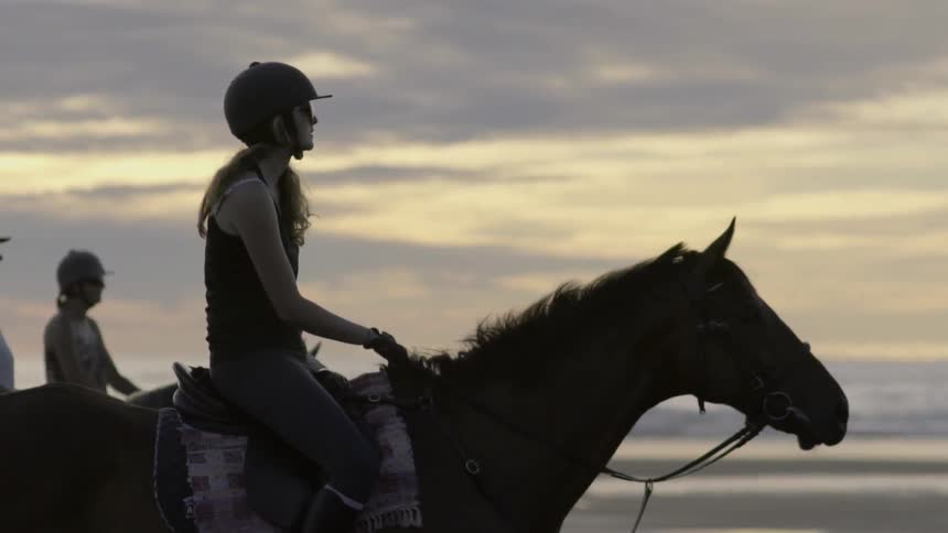 A woman riding a horse moves in the saddle as the horse runs