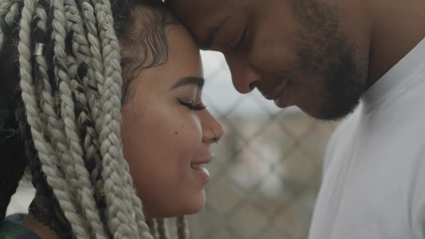 A man and woman are smiling at each other