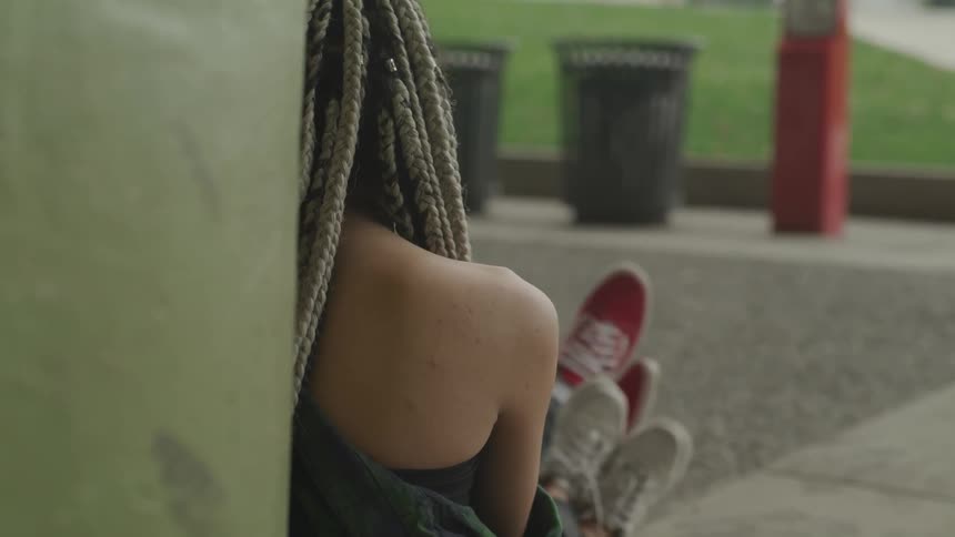 A young couple sits on the cement with their legs crossed