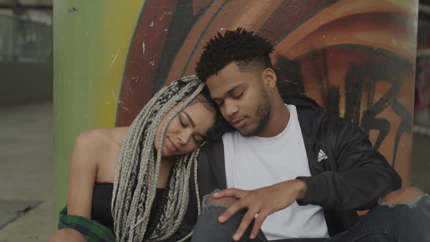 A couple sits together with eyes closed