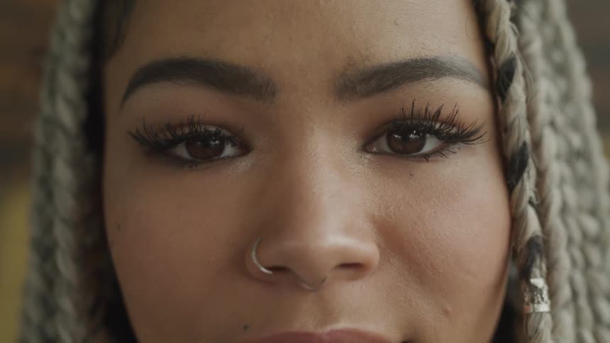 A woman with nose rings staring and smiling