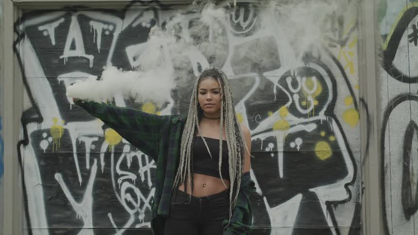 A woman holds up a smoke bomb
