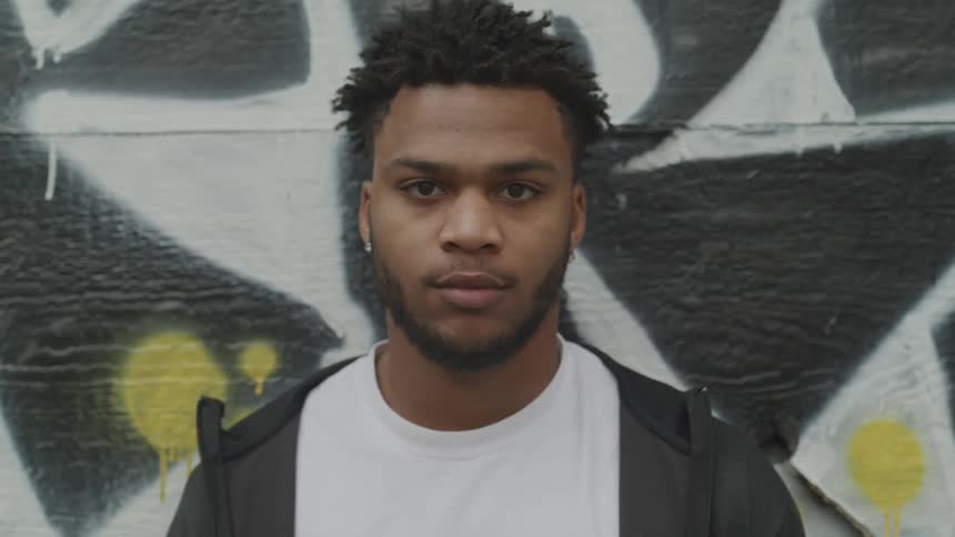 Young black man looks at the camera