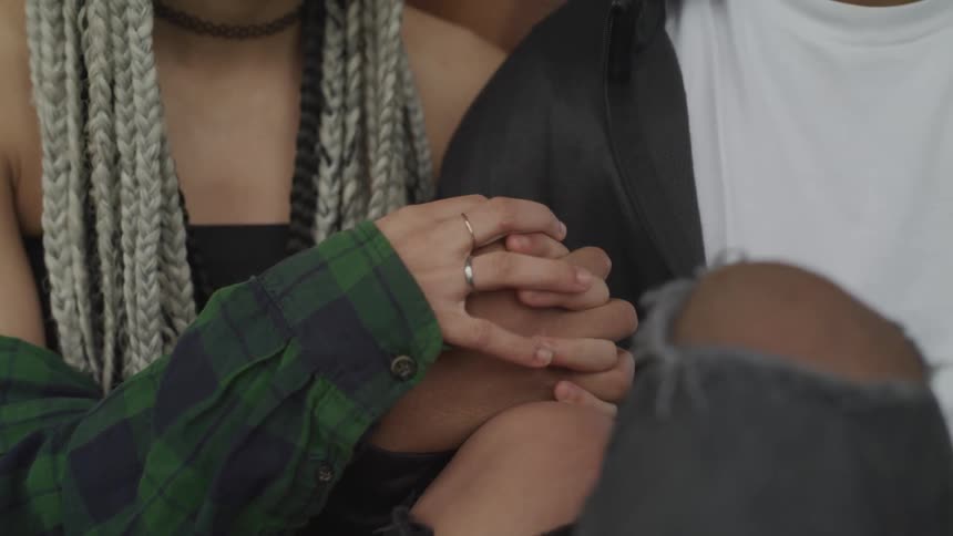 A man and a woman interlocking fingers