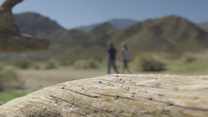 A man and woman walk through the badlands