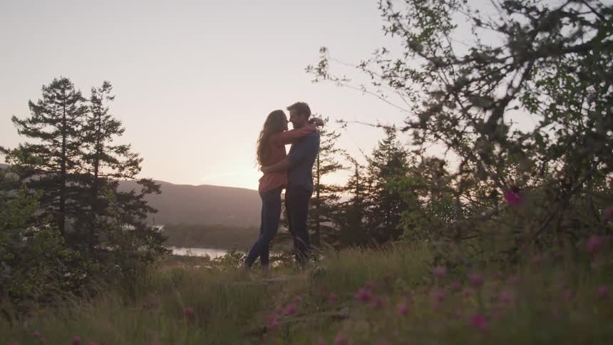 A couple embrace each other in the wilderness