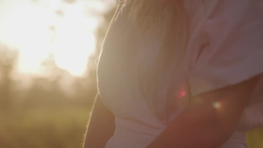 Woman stands in a field under the bright sun