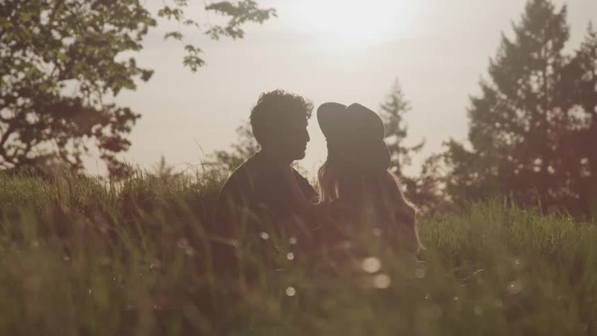 A man and woman are sitting in the grass