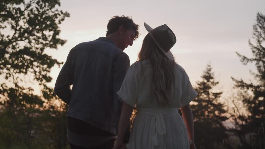 A woman and man are holding hands outdoors