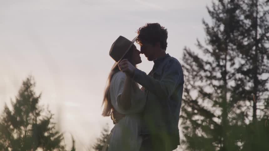 A couple dances in the grass