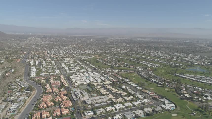 A neighborhood with houses and roads with the sky in the background