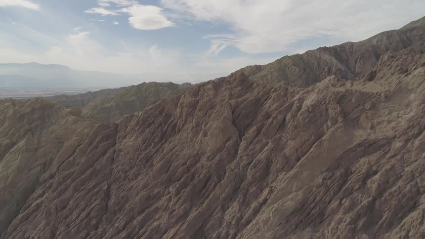 A rocky canyon with the clouds and the sky in the background