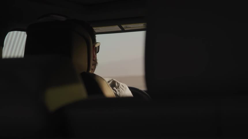 A man with sunglasses driving a car