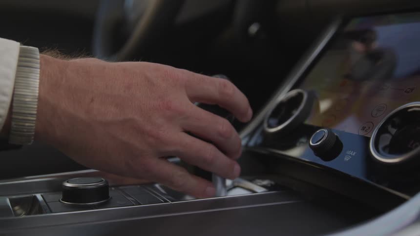 Man hand controlling car transmission