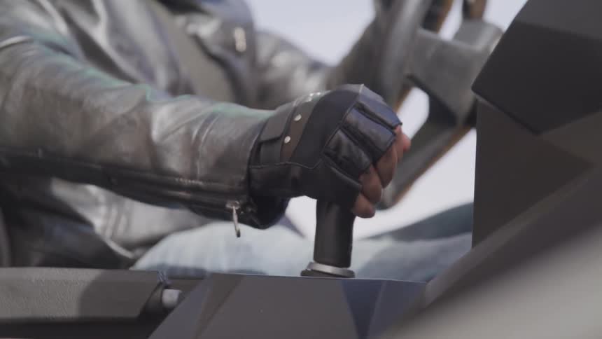 A driver quickly shifts gears in an open vehicle