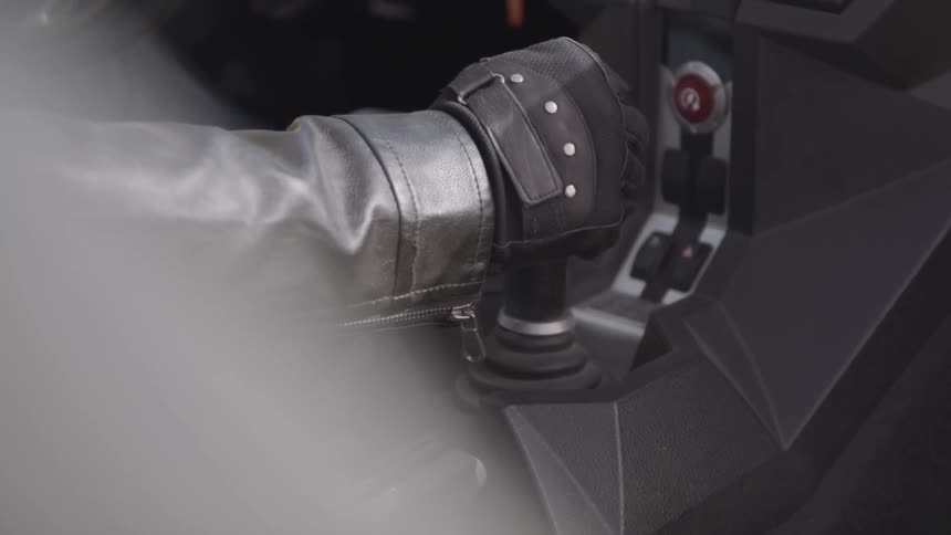 A drivers gloved hand quickly shifts gears