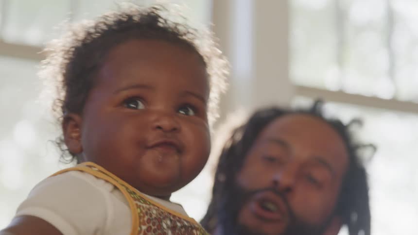 A man bounces a baby up and down