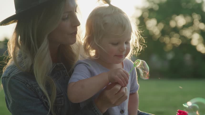 Mother and daughter blowing bubbles