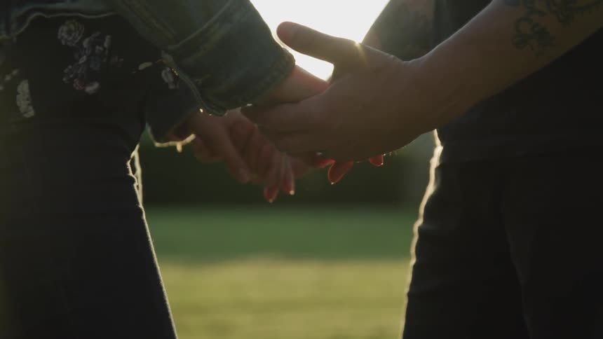 Two people hold hands