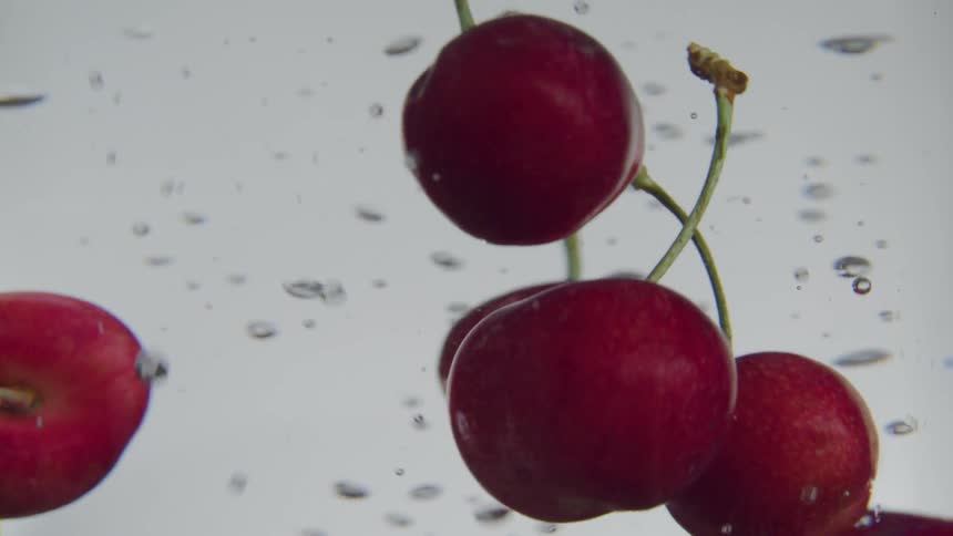 Cherries floating in liquid with bubbles
