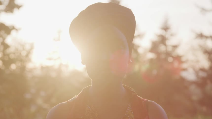 A portrait of black woman at the sunset in the middle of a park