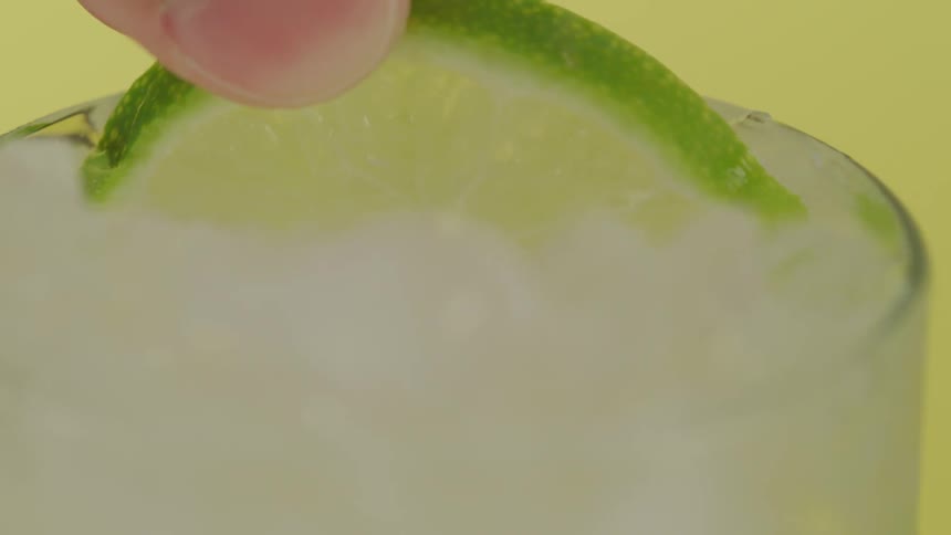 Lime dropping into a glass of liquid