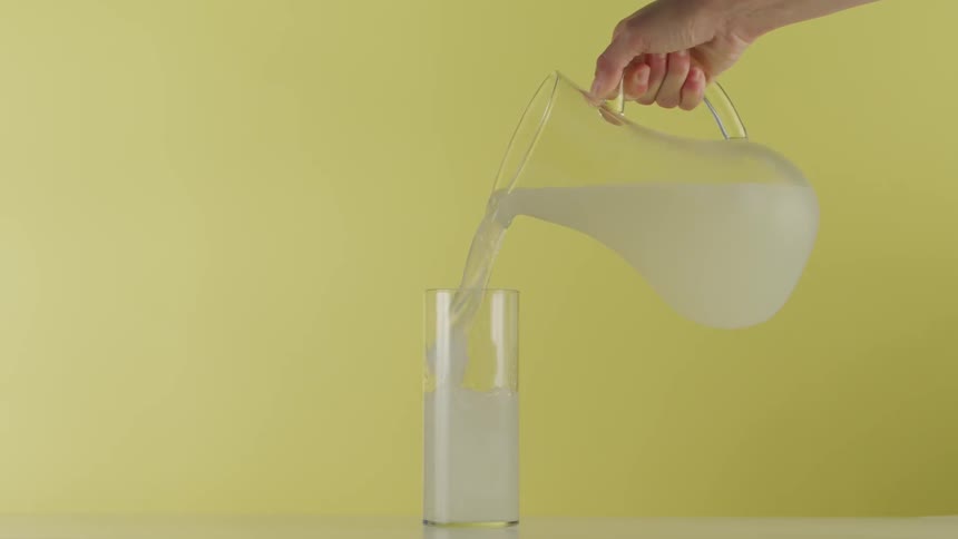 Person pouring an ice drink into a cup