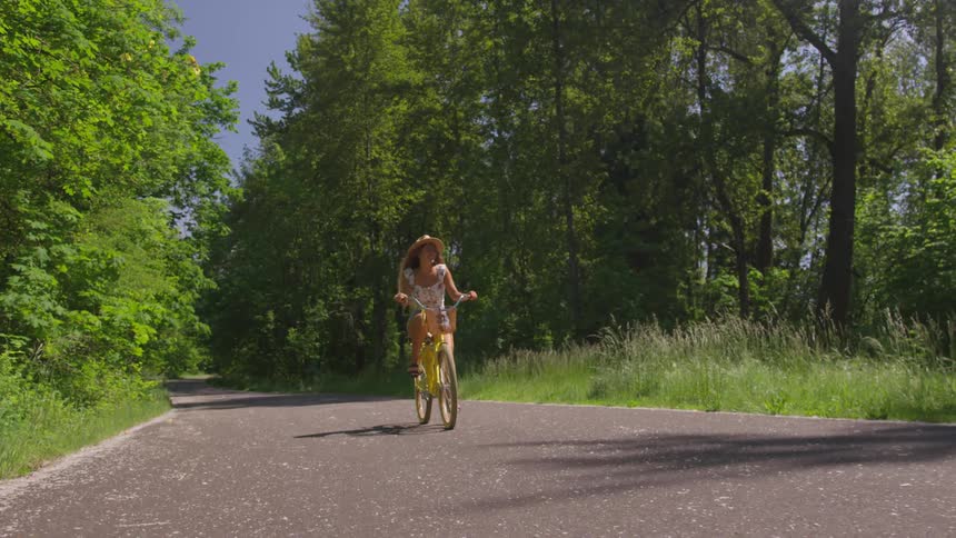 A woman bikes down the road