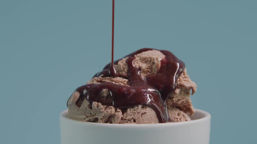 Chocolate sauce is drizzled over chocolate ice cream