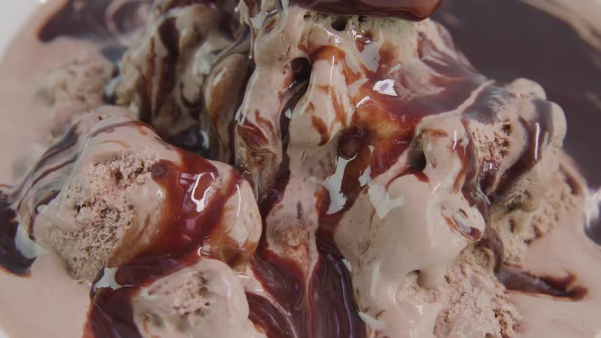 Ice cream melting and covered in chocolate sauce