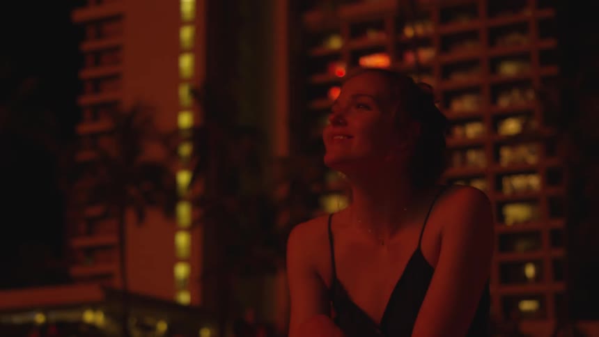 A woman outside at night looking at fireworks
