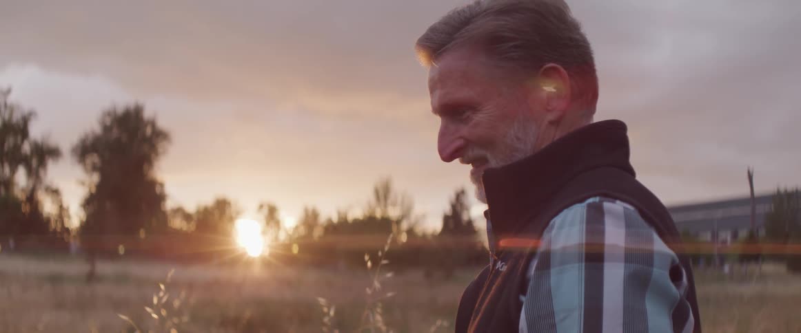 A man stands in a field smiling