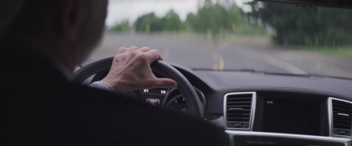 Man driving luxury car down the road