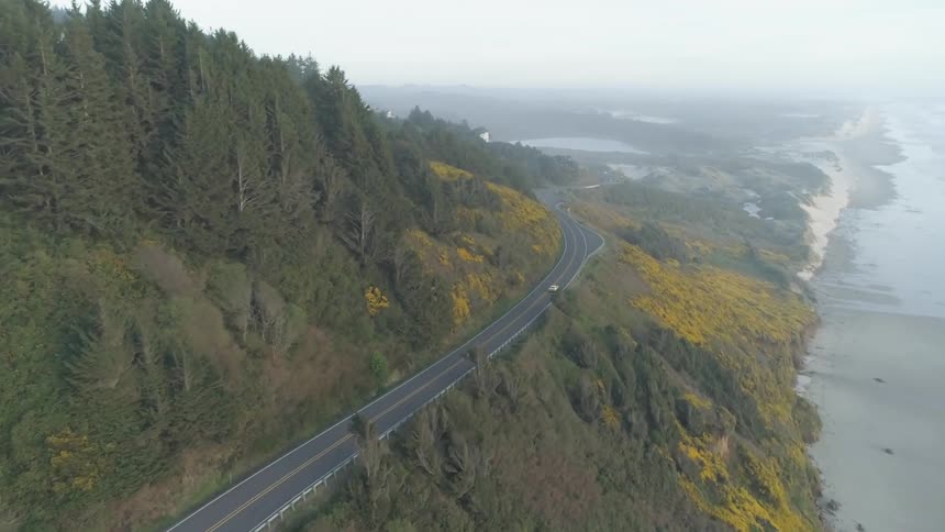 A car driving on a road near the coast