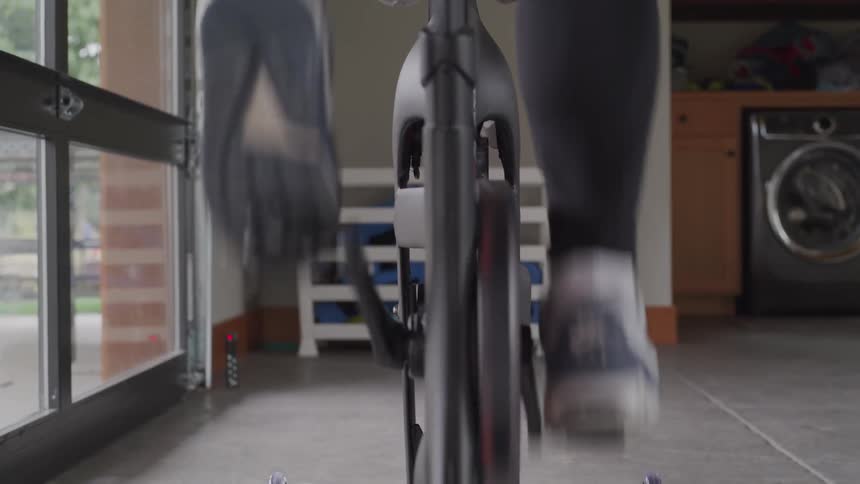 A woman pedals on a stationary bike