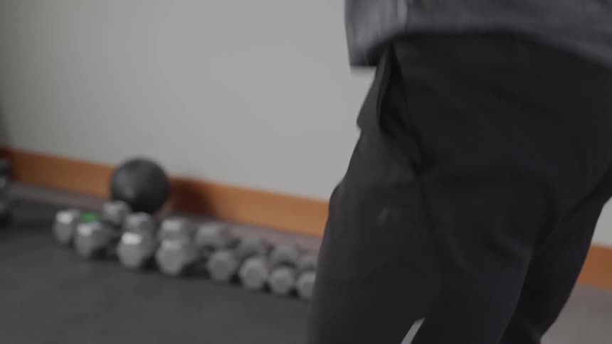 A man bends down and lifts a weight bar