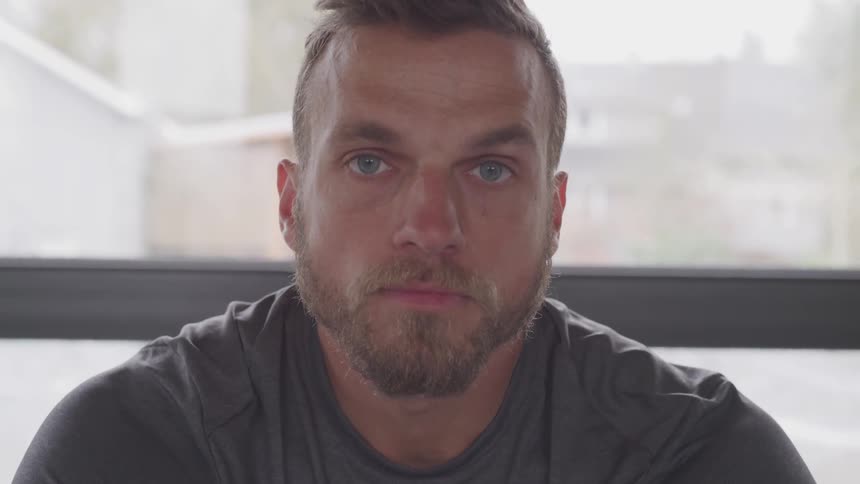 Man sits by window staring