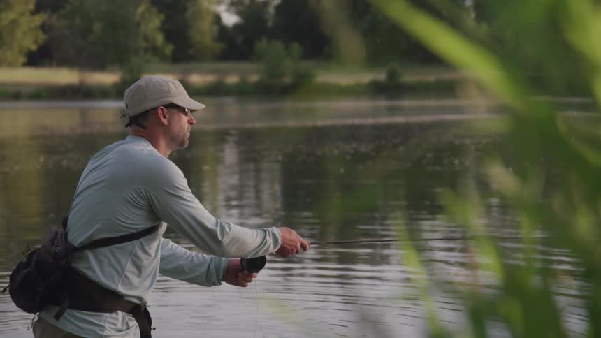 A man holds a fishing pole and pulls on the line