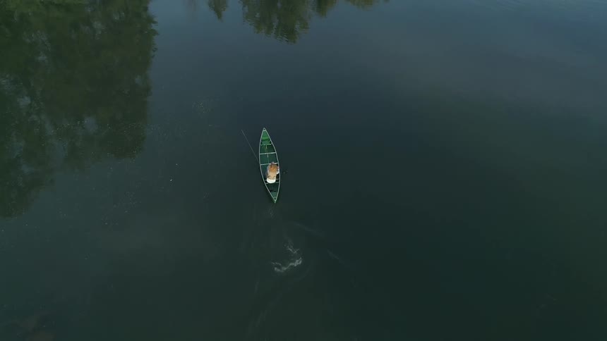A person paddling a canoe through a lake